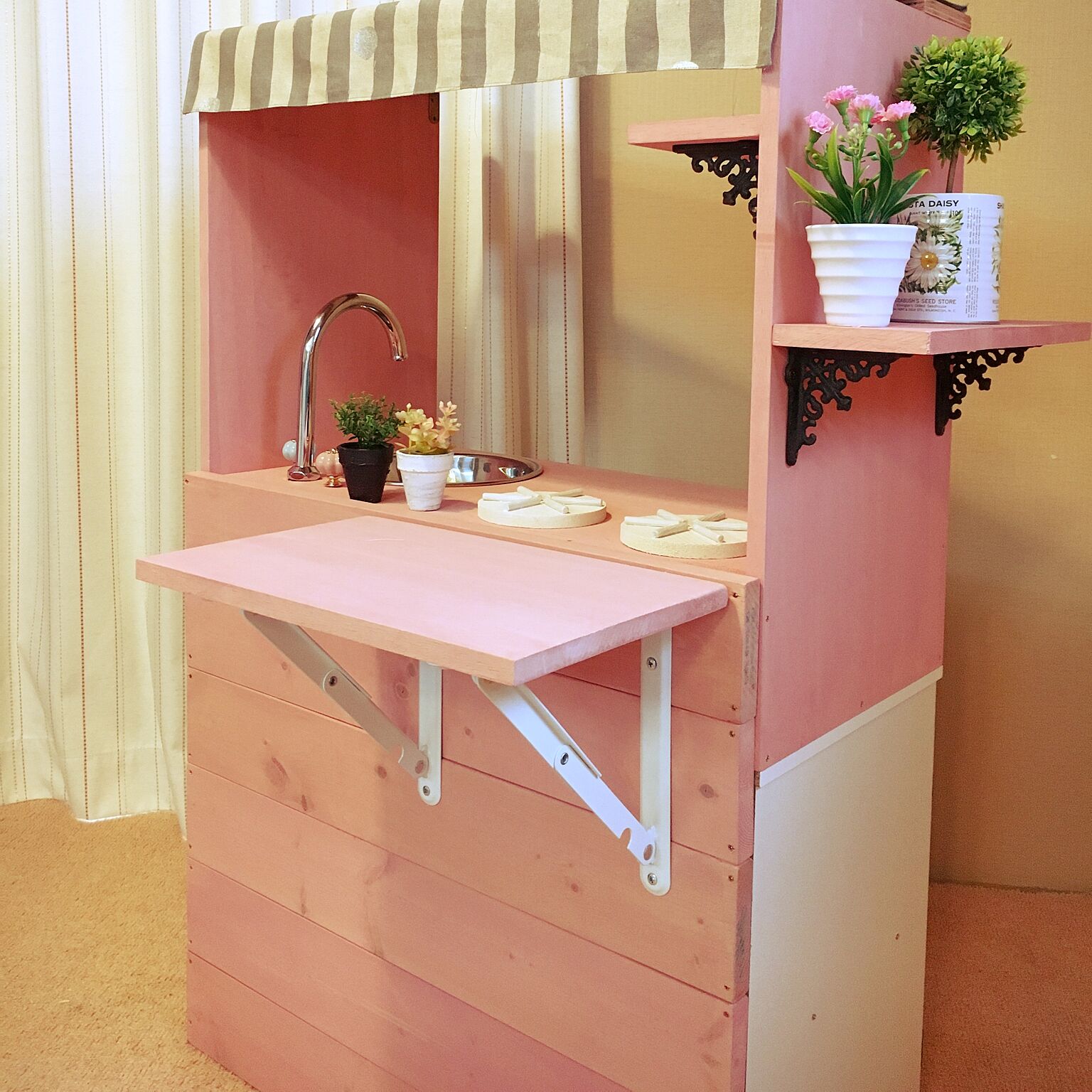 ピンク色で作りましたが、上にかけたストライプの布で甘すぎないデザインです。対面式キッチンがおしゃれ。